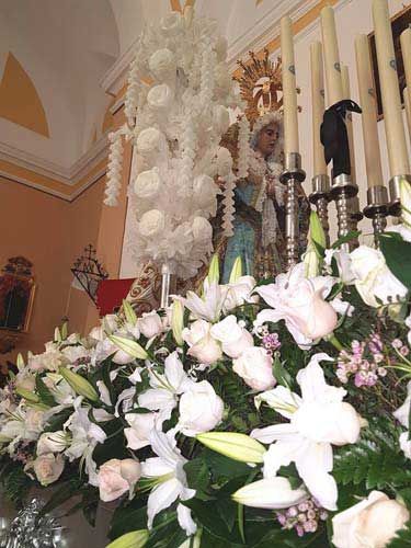Floristería Clío Altar con virgen con flores y velas